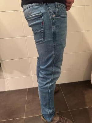 Replay ljusblå slim jeans - Snygga ljusblå jeans från Replay modell anbass. Jeansen har en slim passform och raka ben, tillverkade i mjukt denimtyg med lite stretch för extra komfort. Endast använda fåtal gånger. Först till kvarn!