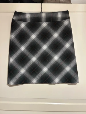 Rutig kjol - Grå/vit-rutig kjol med rak passform. Använd två gånger. 