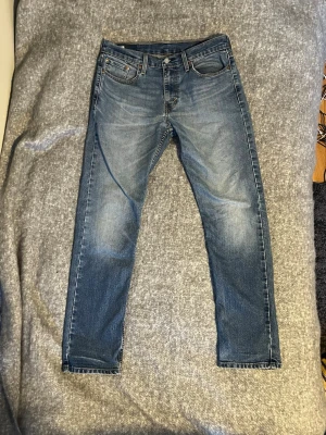 Levis 502 - Tjena! Säljer nu ett par Levis 502 i storlek 30/32. Dem har en snygg blå tvätt och sitter slim/straight. Inte en ända slitning förutom att Levis lappen på rumpan har ramlat av. Vilket jag tycker gör jeansen snygga. Nypris ligger på runt 1300 och jag säljer för 349, kom gärna med frågor och priset kan diskuteras!
