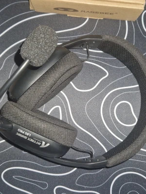 Attack Shark L80 Pro gamingheadset wireless - Säljer ett svart Attack Shark L80 Pro gamingheadset med mjuka over-ear-kuddar och justerbar mikrofon. Headsetet har en robust båge klädd i tyg och ansluts med kabel, trådlöss. Perfekt för gaming eller videosamtal.