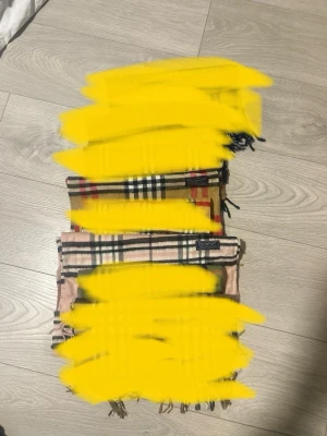 Beige rutig halsduk med raffe pikéer  - Klassisk beige halsduk med rutigt mönster i svart, vitt och rött. Halsduken har fransar i ändarna och känns riktigt tidlös och snygg till alla outfits. Perfekt accessoar för att lyfta din stil. Med raffe pikéer 