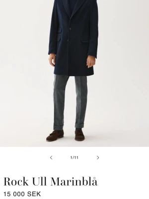 Marinblå rock Rose & Born - Snygg marinblå rock i ull med klassisk krage och två knappar framtill. Rocken har fickor med lock och en stilren, rak siluett som passar perfekt till höst och vinter. Enkel att matcha med både jeans och kostymbyxor. Gjord i kaschmir blend från Rose & Born, handgjord i Italien, nypris 15000kr. Storlek 46