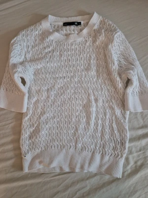 Vit stickad tröja - Säljer en vit stickad tröja från lager 157 i storlek XS. Tröjan har ett luftigt hålmönster, rund halsringning och ribbade muddar vid ärmslut och nederkant. Perfekt för en fräsch look. Oanvänd utan lappar kvar. Hund finns I hemmet.