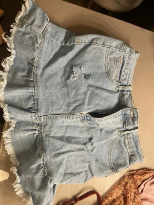 Jeans kjol - Kjol med fina volanger runt för en sommar dag med stiliga hål till för en stilig sommar look 