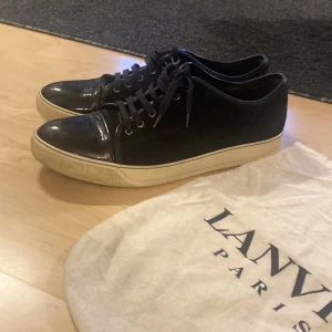 Lanvin cap toe - Hallö! Jag säljer dessa feta Lanvin cap toe. Dessa skor är ett par svarta mockaskor med glans ifram. Hör av er vid funderingar! Bonus: vid köp av fullpris så får ni med en leverantör.