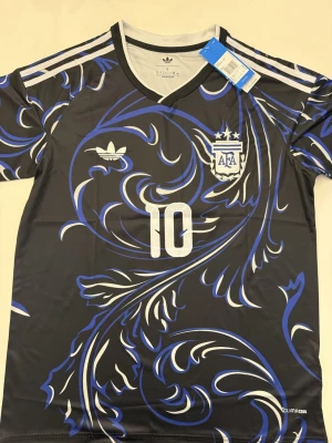 Lionel Messi Argentina 25/26 tröja - Fotbollströjor i storlek M Helt ny och oanvänd, med tag kvar. Detaljrik i inofficiell version. 