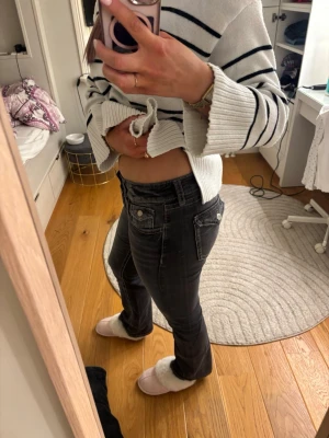 Svarta bootcut jeans med slitningar - Snygga svarta jeans med bootcut-modell och diskreta slitningar på låren. Jeansen har klassisk femficksdesign och silverfärgade knappar och nitar. Perfekta för dig som gillar en tidlös look med lite edge. Är i storlek 170 ifrån Gina tricot. Har inga defekter o jag är 178 cm och de är ungefär 5 cm förkorta för mig 