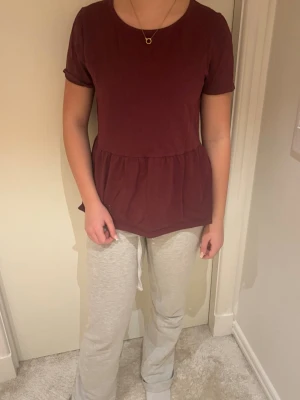 Vinrött loungewear-set från Lindex - Mysigt loungewear från Lindex med vinröd topp i mjukt materialPerfekt för chill hemma eller slappa dagar. T-shirten har en lätt rynkad midja för en avslappnad look.