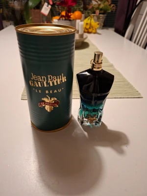 Jean Paul Gaultier Le Beau EdP 75ml - Jean Paul Gaultier Le Beau Eau de Parfum i 75 ml flaska. Flaskan har en unik design i form av en manlig torso i svart och turkost glas med gulddetaljer. Kommer i en grön metalltub med guldlock och tydlig logga. En ikonisk och lyxig herrdoft.