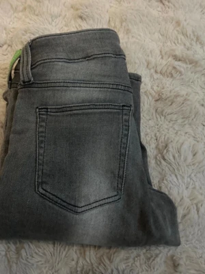 Grå bootcut jeans med slitningar - Snygga grå jeans med bootcut passform och slitna detaljer längs benen. Jeansen har klassiska bakfickor och är tillverkade i ett mjukt denimtyg sopassar perfekt till en avslappnad stil. Perfekta för dig som gillar en lite vidare siluett. Har även sytt upp dom lite typ 3cm.❤️