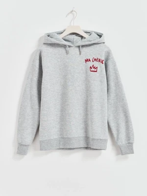 Grå ma chérie hoodie  - Snygg grå hoodie med huva. På bröstet och ryggen finns röd text 'MA CHÉRIE' och en röd krona tryckt. Hoodien har ribbade muddar och är tillverkad i mjukt sweatshirtmaterial. Tyvärr har själva metall saken på muggarna åkt av därav det billiga priset! ❤️ Orginal pris 250kr!