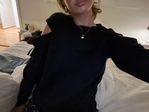 Svart långärmad tröja med snörning - Svart långärmad tröja med coola cut-out detaljer på axlarna och snörning längs ärmarna. Tröjan har en loose passform och är perfekt för dig som gillar en lite edgy stil. Materialet känns mjukt och bekvämt mot huden.