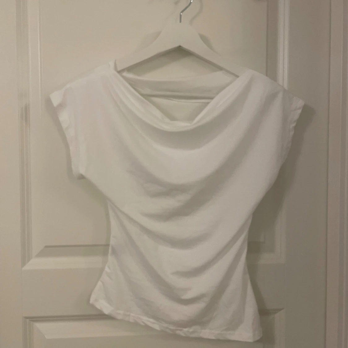 Vit draperad topp med capärm