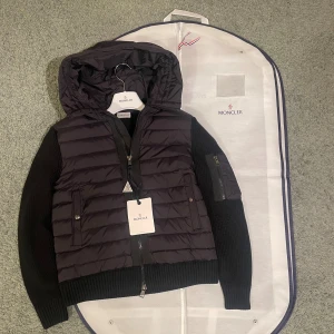 Moncler cardigan  - Jag säljer en Moncler cardigan i svart färg , den kommer med dustbag som och Moncler galja. Den är helt ny och aldrig använd.