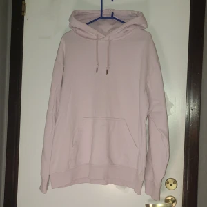 Ljusrosa hoodie från H&M, storlek S - Säljer en ljusrosa hoodie från H&M i storlek S. Tröjan har en klassisk huva med snörning, stor magficka och långa ärmar. Mjuk och skön bomullskvalitet, perfekt för chill dagar. Enkel och stilren design som är lätt att matcha med jeans eller leggings.