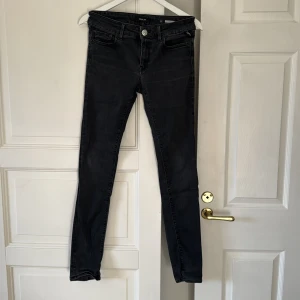 Svarta skinny jeans Replay Luz - Svarta skinny jeans från Replay, modell Luz. Jeansen har klassisk femficksdesign, silverfärgad knapp och smal passform hela vägen ner. Materialet är stretchigt jeans och färgen är tvättad svart med lätt slitning för en cool look.