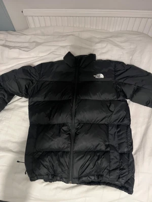 Svart pufferjacka från The North Face - Säljer en svart pufferjacka från The North Face. Riktigt fint skick och en väldigt varm jacka som passar perfekt nu när det börjar bli vinter.