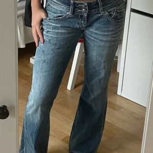 Bootcut jeans - Snygga blå bootcut jeans med unik design från  Hilfiger denim😚  Y2K stil  Midja (rakt över): 41 cm Innerbenslängd: 79 cm Lårvidd: 24 cm