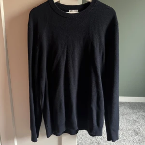 Mörkblå stickad tröja från Cubus - En stilren svart stickad tröja från Cubus med rund hals och långärmad design🔥 Sparsamt använd, Strl L