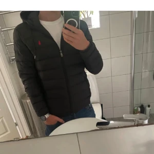 Svart pufferjacka från Polo Ralph Lauren - Säljer denna riktigt snygga jackan från Ralph Lauren. Säljer den då jag har köpt en annan. Storlek S som passar 175cm perfekt. Cond: 9/10. Inga defekter och endast använd under förra vintern. Säljer den för 2699kr, priset kan diskuteras. nypris: 3499kr. 