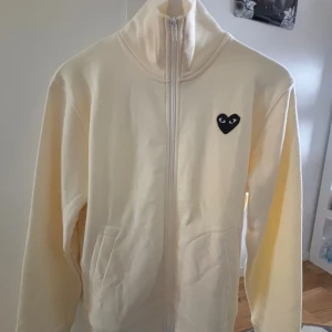 Vit zip Tröja Comme des Garçons Play S - Säljer en vit hoodie från Comme des Garçons Play i storlek S. Tröjan har hel dragkedja. Passar Xs också. Ny aldrig använd bara testad