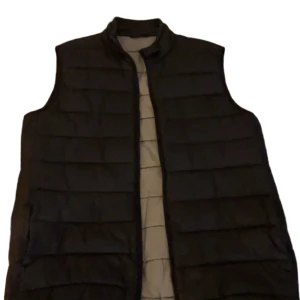 Barbour vest  - Svart quiltad Barbour-väst i storlek S. Lätt vadderad och ärmlös med dragkedja framtill – perfekt som mellanlager under vår och höst. Klassisk, stilren design i typisk Barbour-kvalitet.