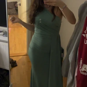 Grön långklänning oneshoulder - Snygg grön långklänning med oneshoulder-design. Endast använd en gång. Klänningen är onesize men skulle säga att den passar S o M❤️