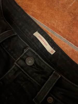 Levi's Superlow Boot svarta jeans - Svarta jeans från Levi's i modellen Superlow Boot med låg midja och bootcut. W-30 L-30. Endast testade 