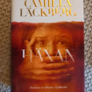 Spännande böcker av Camilla Läckberg i nyskick! - En spännande bok av Camilla Läckberg med texten 'Ondskan är tillbaka i Fjällbacka' på omslaget. Perfekt för dig som gillar mysterier och nervkittlande berättelser. Passar unga vuxna som vill ha en bok som är svår att lägga ifrån sig. 