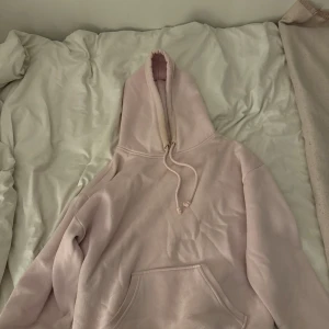 Ljusrosa hoodie med huva och ficka - Mysig ljusrosa hoodie. Tröjan har en relaxed, oversized passform och är tillverkad i mjukt material som känns skönt mot huden. Perfekt för hösten när du vill ha en enkel och stilren look.