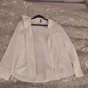 Vit skjorta från H&M Divided, stl S - Klassisk vit skjorta från H&M Divided i storlek S. Skjortan har lång ärm, bröstficka och knappar framtill. Perfekt för en clean och stilren look. Materialet känns lätt och bekvämt. Bara provat en gång väldigt bra skick! Passar medium också!🎀