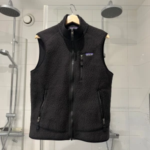 Svart fleeceväst från Patagonia - Snygg Svart fleeceväst från Patagonia med hög krage och hel dragkedja framtill. Använda men inga slitningar eller fläckar. Kom med prisförslag 