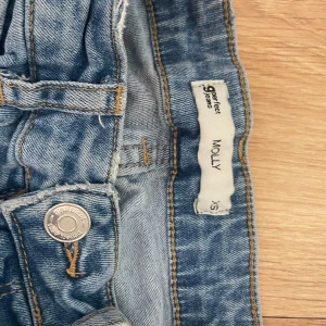 Molly jeans från Gina Tricot XS - Ljusblå Molly jeans från Gina Tricot i storlek XS. Högmidjade med skinny passform och klassiska femficksdetaljer. Jeansen har dragkedja och knapp framtill samt råa benslut för en trendig look. Perfekta för dig som gillar en tight och bekväm stil. Säljs sv ingen andvändning.