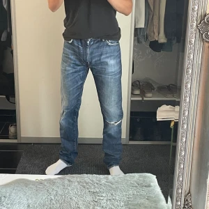 Levi's 508 blå jeans W33 L34 - Snygga blå Levi's 506 jeans med klassisk femficksdesign och slitning på vänster knä. Jeansen har raka ben, mellanblå tvätt och coola slitdetaljer. Perfekta för dig som gillar en avslappnad och tidlös look.