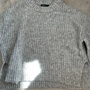 Grå stickad tröja från Gina Tricot - Supermysig grå stickad tröja från Gina Tricot med ribbade muddar och rund hals. Tröjan har en loose fit och är perfekt för kyliga dagar. Den är mjuk och har en snygg, enkel look som passar till allt. 💘💘