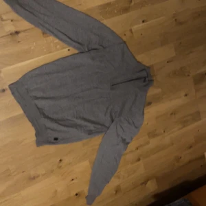 Grå polotröja från Sand Copenhagen - Snygg grå polotröja från Sand Copenhagen med lång ärm och klassisk passform. Tröjan är tillverkad i mjukt material och har en stilren look som funkar till många olika outfits. Perfekt för dig som gillar enkel och clean stil.