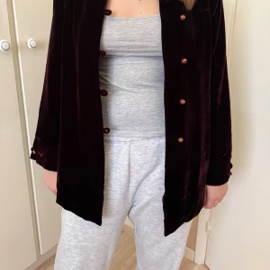 Vinröd sammet kavaj från Monalisa - Säljer en vinröd kavaj i mjuk sammet från Monalisa. Kavajen har lång ärm, klassisk krage och snygga knappar framtill. Perfekt för dig som vill ha en elegant och unik look med lyxig känsla. Passar dig som gillar statement-plagg och vill sticka ut.