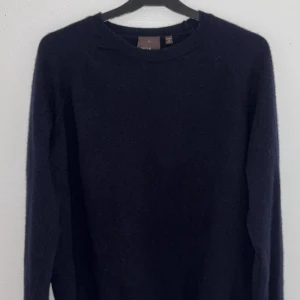 Ulltröja Oscar Jacobson Marinblå - En enkel och stilren marinblå ulltröja från Oscar Jacobson. Storlek S. Perfekt inför kommande höst och vinter.