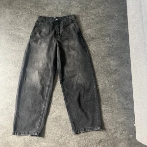 Baggy jeans  - Säljer ett par svarta jeans från Bershka i storlek 38. De har en loose och wide passform med hög midja och raka ben. Jeansen är tillverkade i bomull och har klassiska fickor både fram och bak. Perfekta för en avslappnad och trendig look.