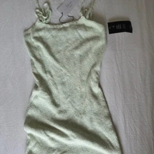 Kort klänning NA-KD - Kort klänning från NA-KD, upplevs som ”stickad” i materialet. Helt oanvänd med lapparna kvar, är från en kollektion med Hanna Schönberg X NA-KD. Skitsnygg att ha tex utomlands!!