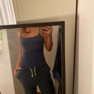 Blue body - Säljer en stilren mörkblå baddräkt med smala axelband och klassisk, rak urringning. Perfekt för dig som gillar en clean och minimalistisk look på stranden eller vid poolen. Sitter tight och följsamt mot kroppen.