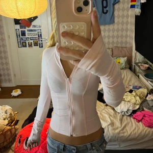 Ljusrosa långärmad topp från Gina Tricot - Supersnygg ljusrosa långärmad topp från Gina Tricot i storlek S. Modellen är croppad med dragkedja framtill och har en slim passform som sitter tajt mot kroppen. Tillverkad i mjukt och stretchigt material, perfekt för att skapa en clean och fräsch look.