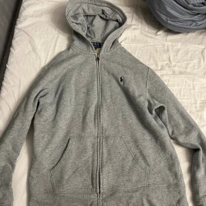 Polo Ralph raulen  - Det är en grå polo Ralph Raulen hoodie som jag säljer för att den är för liten.Den är i väldigt fint skick. Storlek xl i kids size 18-20