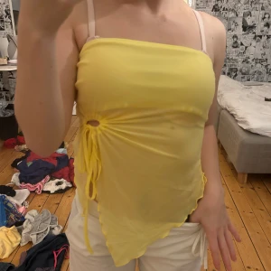 Gul asymmetrisk linnetopp med snörning - Säljer en ljusgul, tunn och asymmetrisk linnetopp med smala axelband. från shein & passar xs-s, aldrig använd