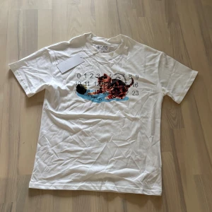 Vit t-shirt Maison Margiela kattmotiv - Tjena, säljer nu denna margiela T-shirten i storlek S. Aldrig använd pga för stor. Legat i garderoben så den är i nyskick. Hör av er vid fler frågor eller funderingar!