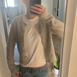 Grå kofta från Gina - Mysig grå kofta från Gina tricot med rund halsringning och knappar framtill. Koftan är stickad. Säljer pga att den inte kommer till användning längre, skriv om ni har frågor!!🤍