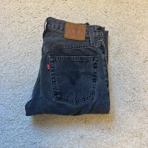 Levi's 501 mörkgråa - Säljer ett par mörkgråa Levi's 501 jeans med rak passform. De är storlek W25, men passar bra till W27 och L32. De har inga synliga defekter eller missfärgningar. Passar till dig som är runt 165-170. Skriv vid intresse!