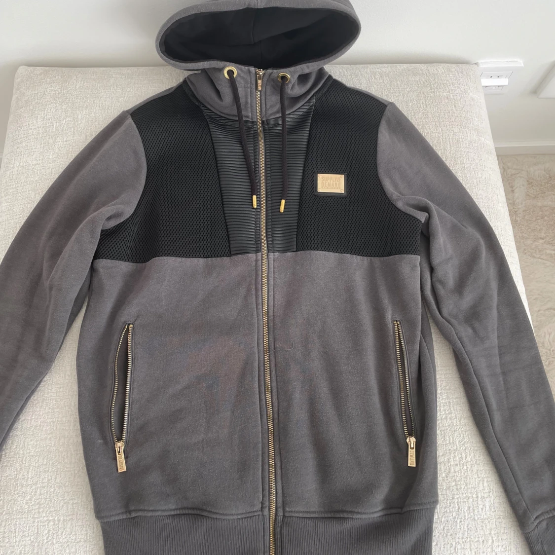 Grå hoodie med svarta detaljer och guldzip