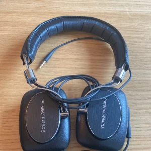 Bowers & Wilkins P5 - Snygga Bowers & Wilkins P5 over-ear hörlurar med kabelanslutning. Levereras med original fodral. Hörlurarna är i gott skick med mindre tecken på användning, och fodralet är något dammigt men funktionellt. Perfekt för högkvalitativ musikupplevelse.