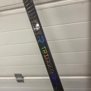 CCM Ribcor Trigger 9 Pro INT - CCM Ribcor Trigger 9 Pro INT hockeyklubba med 65 flex, grip och P29 blad, left. Klubban är aldrig använd. Perfekt för spelare som söker snabb release och lätt vikt. Levereras med originalkartong.